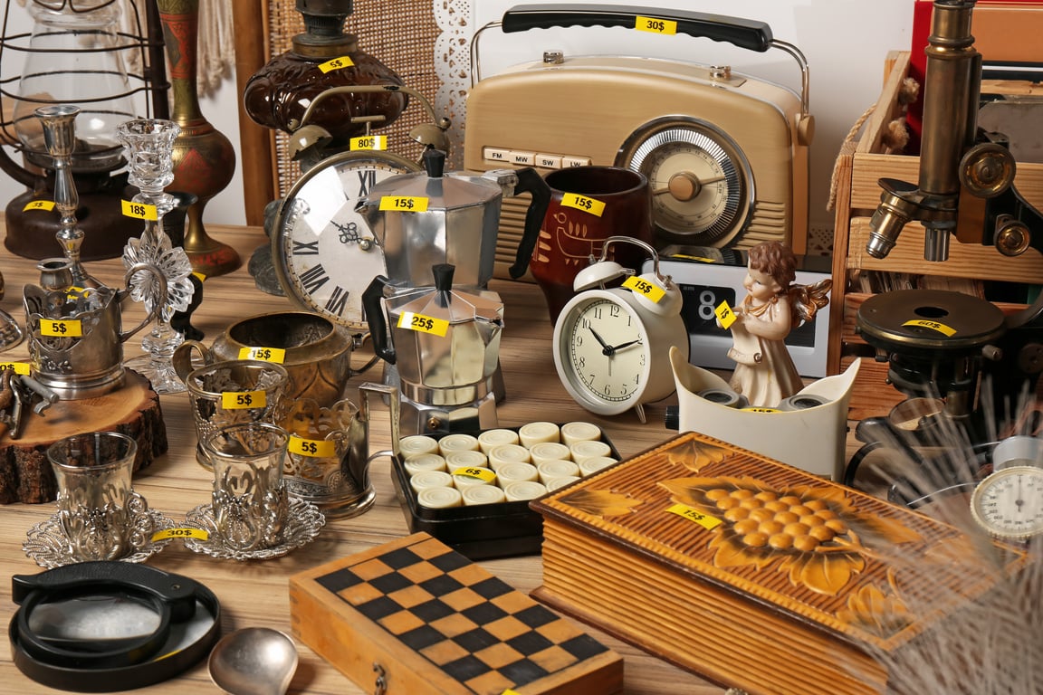 Many Different Items on Wooden Table. Garage Sale